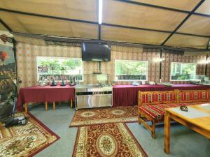 a kitchen with red tables and chairs in a tent at Hotel Green Palace in Sinaia