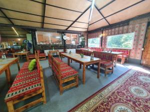 a restaurant with wooden tables and red chairs and a table at Hotel Green Palace in Sinaia
