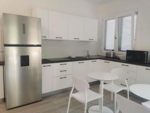 a kitchen with a stainless steel refrigerator and a table at Puntaalarooms in Punta Ala