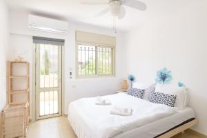 a white bedroom with a large white bed and windows at Luxury Villa, Terrace with SEA VIEW in the center in Netanya