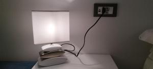 a lamp sitting on a table in a bedroom at Puntaalarooms in Punta Ala