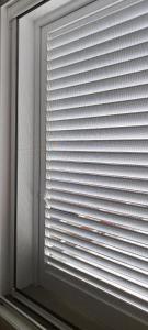 a window with the blinds on it in a room at Puntaalarooms in Punta Ala