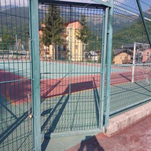 einen Schlagkäfig mit einem Tennisplatz darin in der Unterkunft Casa Vacanze Limone in Limone Piemonte