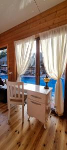 a white desk and a chair in a room with windows at Olympos Village Relaxury Hotel in Olympos