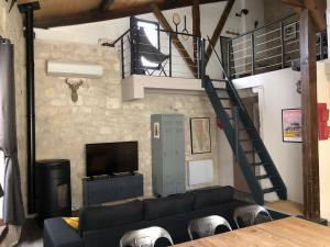 a living room with a couch and a staircase at Loft de charme centre de Montcuq in Montcuq