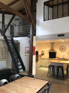 una cucina e una sala da pranzo con una scala e un tavolo di Loft de charme centre de Montcuq a Montcuq