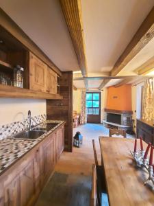 cocina con armarios de madera, fregadero y mesa en Derby Village, en Villaret