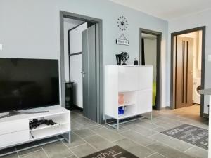 a living room with a tv and a white entertainment center at Sunset Villa in Siófok