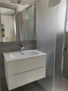 a bathroom with a white sink and a mirror at Puntaalarooms in Punta Ala