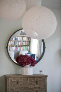 un espejo sobre una mesa con un jarrón de flores en Hotel Rezi, en Parga
