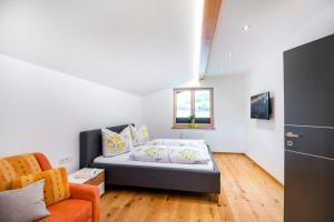 ein kleines Zimmer mit einem Bett und einem Sofa in der Unterkunft Landhaus Rosner in Dorfgastein