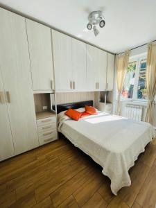 1 dormitorio con 1 cama con armarios blancos y almohadas de color naranja en Beds house, pace e tranquillità a 5 min dal mare.., en Vescina