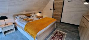 a bedroom with a large bed with a yellow blanket at Level780 in Koszarawa