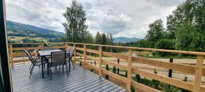 a wooden deck with a table and chairs on it at Level780 in Koszarawa