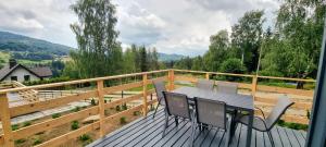 a deck with a table and chairs on a balcony at Level780 in Koszarawa
