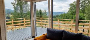 a room with a balcony with a couch and a large window at Level780 in Koszarawa