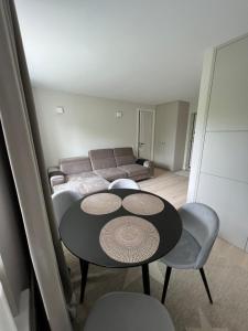 Biliūno apartamentai prie jūros في بالانغا: غرفة معيشة مع طاولة وأريكة