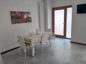 a white dining room with a table and chairs at Nic House in Venice