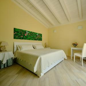 ein Schlafzimmer mit einem Bett und einem Gemälde an der Wand in der Unterkunft Corte dei Mirti, Appartamento indipendente con ampia veranda in Iglesias