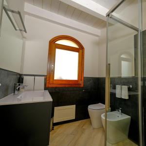 ein Badezimmer mit Waschbecken und Toilette und einem Fenster in der Unterkunft Corte dei Mirti, Appartamento indipendente con ampia veranda in Iglesias