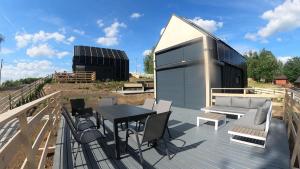 a deck with a table and chairs and a building at Level780 in Koszarawa