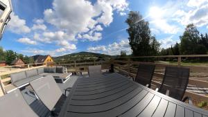 a deck with a couch and chairs on it at Level780 in Koszarawa