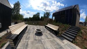 two benches sitting on a wooden deck in front of a building at Level780 in Koszarawa