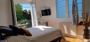 a bedroom with a bed and a large window at L'entre deux Eaux 'Maison' Balcon 'et Jardin in Reims