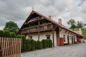 a house with a wooden roof with a balcony at Penzion U Skutilů in Pilníkov