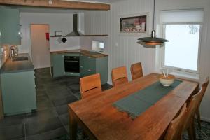 cocina y comedor con mesa de madera en Nesseby Guesthouse en Varangerbotn