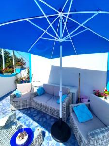 een blauwe paraplu bovenop een patio bij Santa Margherita Suite in Procida