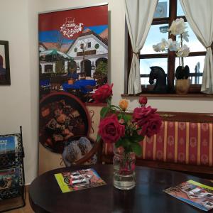 een tafel met een vaas met bloemen erop bij Gastland M1 Hotel & Conference Center in Páty