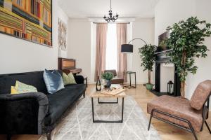 uma sala de estar com um sofá preto e uma mesa em Elegant 3Bed Apartment in Kensington Olympia em Londres