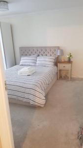 a bedroom with a large bed with a pillow on it at Lovely 2 bedroom flat in the heart of water Wimbledon in London