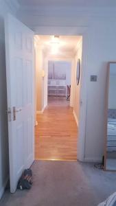a hallway leading to a room with a white door at Lovely 2 bedroom flat in the heart of water Wimbledon in London