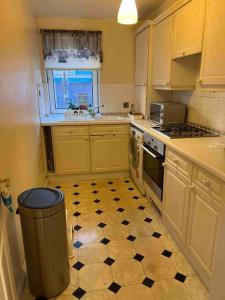 a kitchen with a black and white checkered floor at Lovely 2 bedroom flat in the heart of water Wimbledon in London