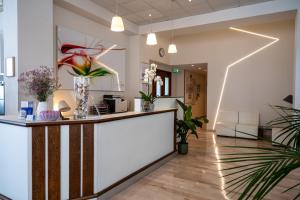 a lobby with a reception counter and plants at Hotel Globus in Bellaria-Igea Marina
