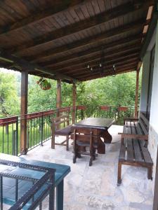 a patio with a ping pong table and benches at Бадевски рай-къща Надежда in Badewzi