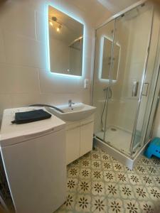 a bathroom with a shower and a sink and a mirror at I - Apartament na Warmi dla rodzin z dziećmi in Gietrzwałd