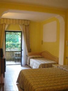 a hotel room with two beds and a balcony at Platani Hotel in Bolsena