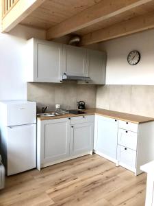 a kitchen with white appliances and a wooden floor at DOMIKO in Mikoszewo