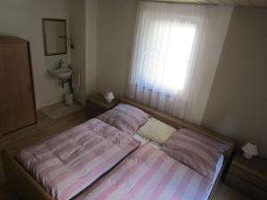 Schlafzimmer mit einem Bett, einem Fenster und einem Waschbecken in der Unterkunft Ferienwohnung Liesel in Hornberg