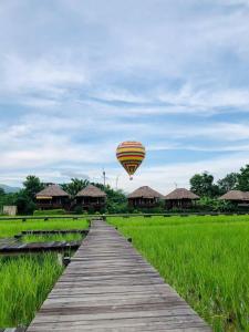 a hot air balloon flying over a wooden bridge at ViengTara VangVieng Resort in Vang Vieng