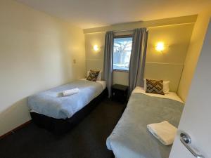 Habitación con 2 camas y ventana en Central Park Motor Lodge en Christchurch
