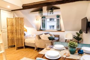 a living room with a couch and a table at Spacious studio in Paris Hyper Center - Smart TV & WIFI - 4P in Paris