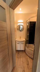 a bathroom with a tub and a sink and a mirror at Astronomiczny apartament , mieszkanie 2 pokojowe. Parking. in Toruń
