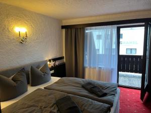 a bedroom with a bed and a large window at Weidach Bergblick in Leutasch +23 photos