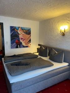 a bedroom with a bed with a painting on the wall at Weidach Bergblick in Leutasch