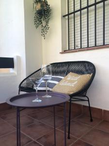 deux verres à vin sur une table à côté d'une chaise dans l'établissement Playa Laguna Bajo Parking, à Chipiona