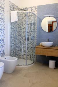 a bathroom with a shower and a toilet and a sink at Villetta Scruscio ri Mare in Favignana